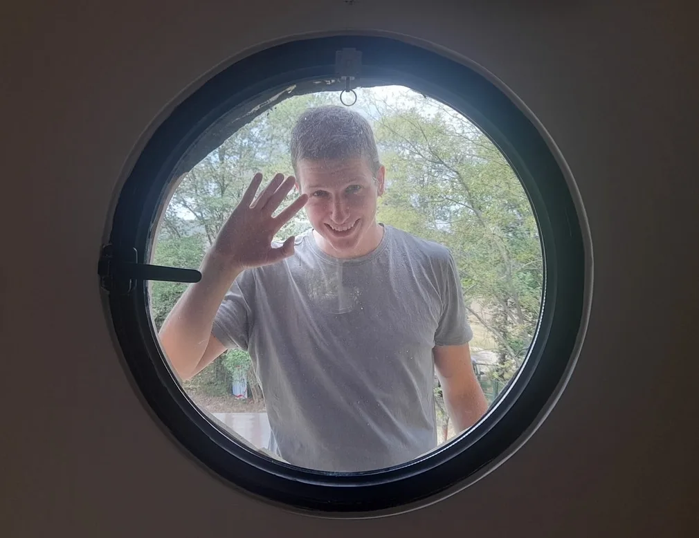 Jakub Mertl mává přes kulaté okno